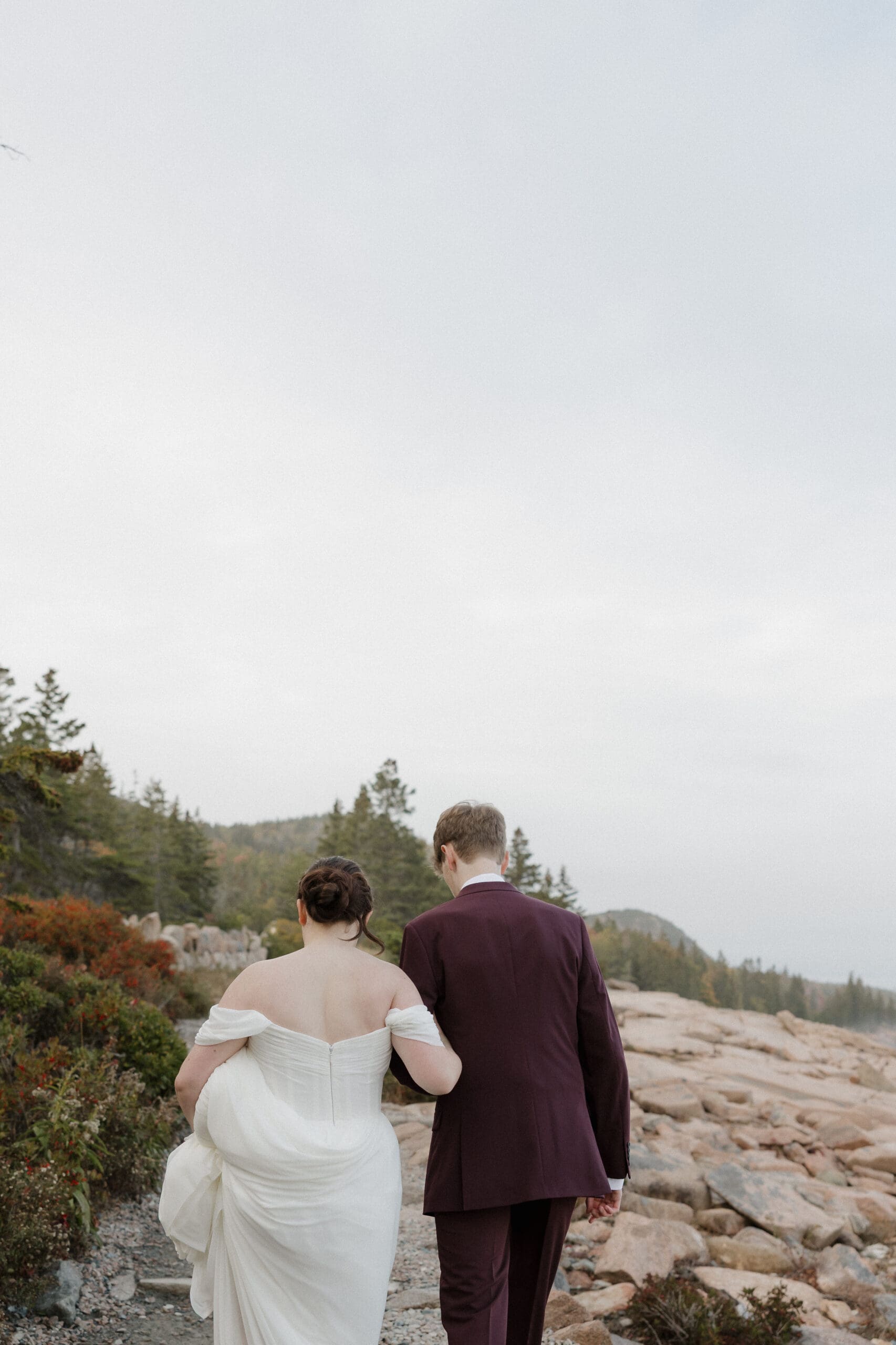 elopement couple walking on cliff path in acadia national park